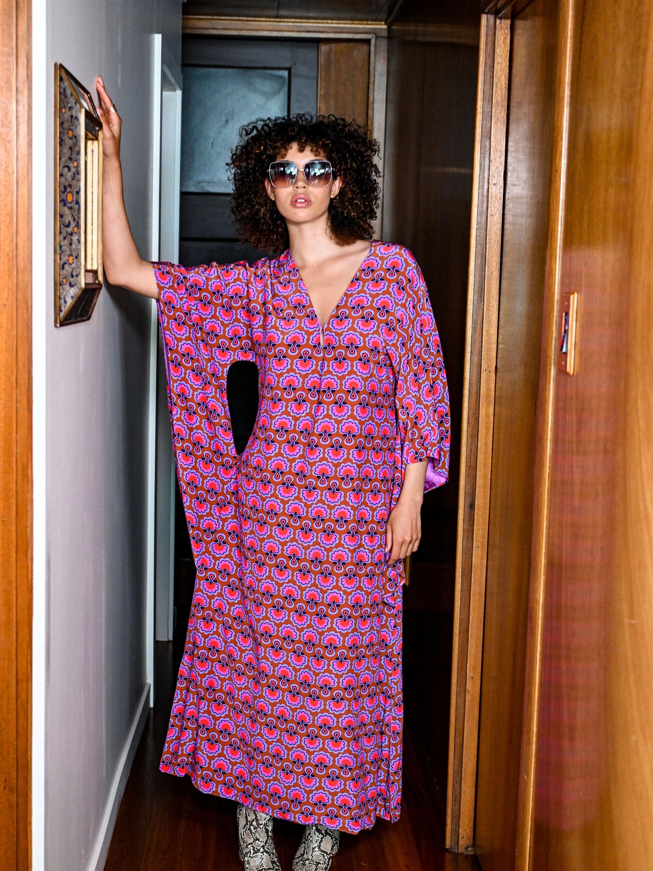 Front view worn loose in a wood-panelled hallway, Dahlia Seed matte viscose kaftan