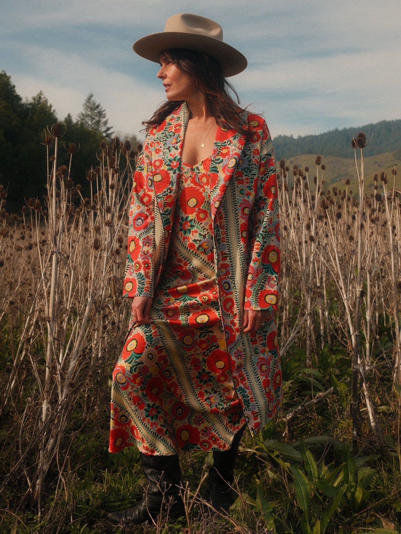 Worn open over a matching slip dress among teasels, Matyó Floral brushed cotton car coat
